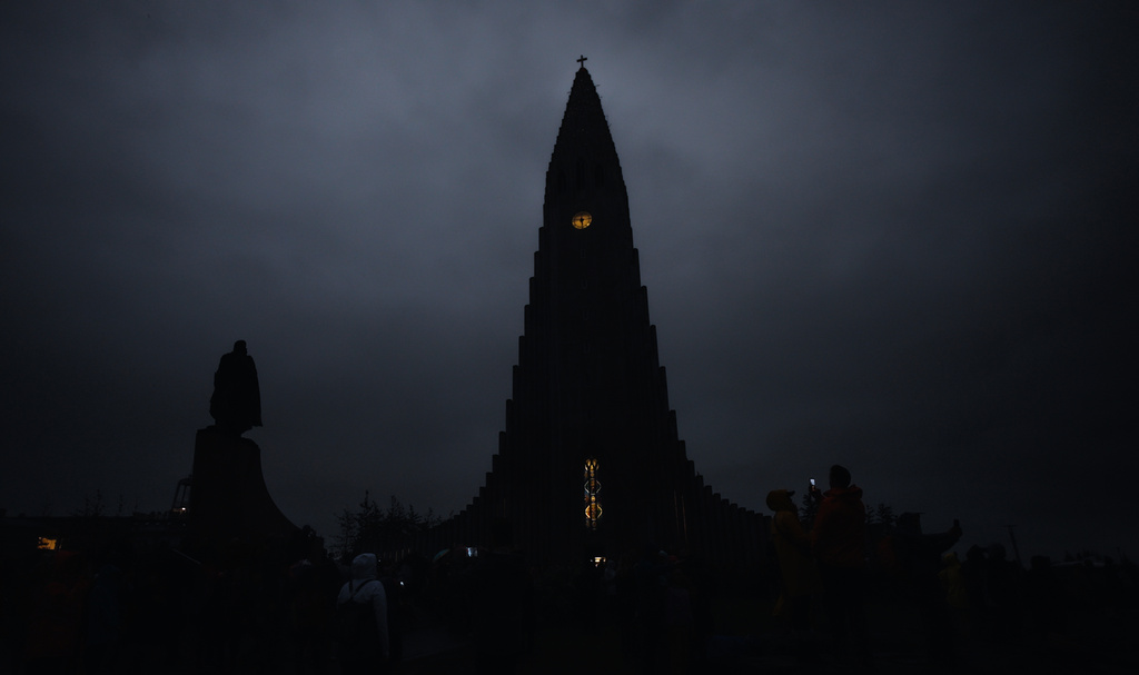 The Hallgrímskirkja church is seen in the dark during a total solar eclipse on a cloudy day in Reykjavik, Iceland, Wednesday, Aug. 12, 2026. (AP Photo/Marco di Marco)