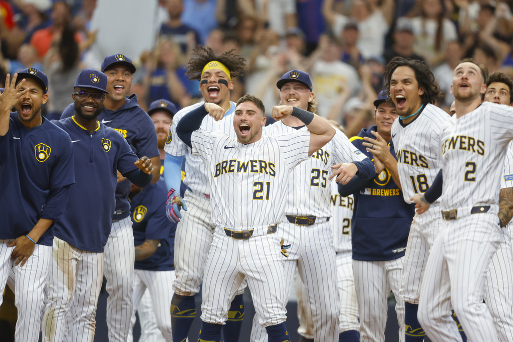 The Milwaukee Brewers wait for teammate Isaac Collins who hit a walk-off home run during the ninth inning of a baseball game against the New York Mets, Sunday, Aug.10, 2025, in Milwaukee. (AP Photo/Jeffrey Phelps)