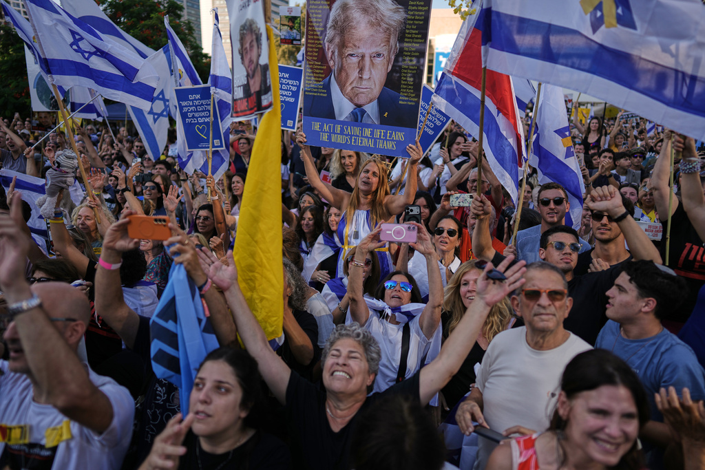 People react as they gather to watch a live broadcast of Israeli hostages released from Gaza at a plaza known as hostages square in Tel Aviv, Israel, Monday, Oct. 13, 2025. The release took place as part of a cease-fire agreement between Israel and Hamas. (AP Photo/Oded Balilty)