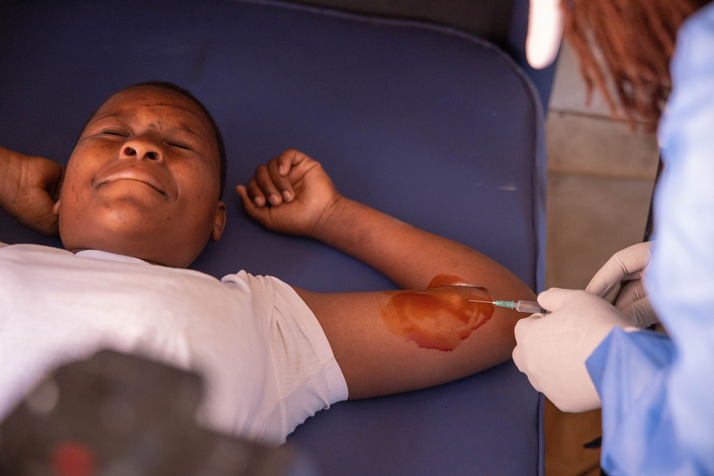 Chenai Mukucha reacts as a birth control implant is administered inside a caravan at Epworth Poly Clinic in Epworth, Zimbabwe, Tuesday, Aug. 25, 2026. (AP Photo/Aaron Ufumeli)