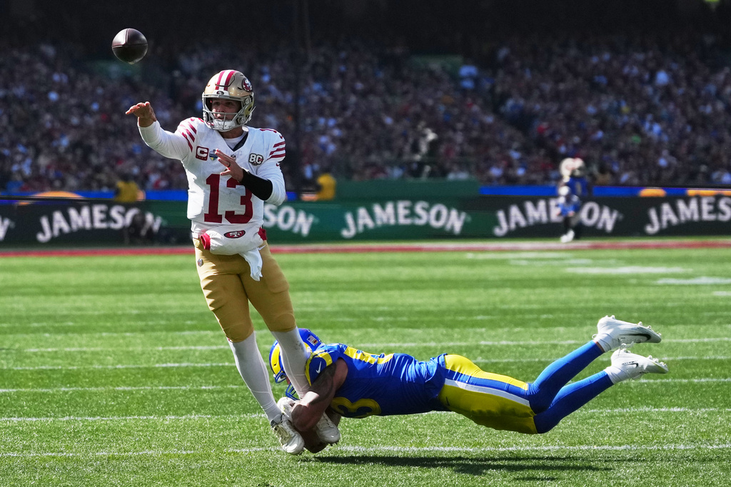 San Francisco 49ers quarterback Brock Purdy passes under pressure from Los Angeles Rams linebacker Nate Landman during the first half of an NFL football game Friday, Sept. 11, 2026, in Melbourne, Australia. (AP Photo/Asanka Brendon Ratnayake)