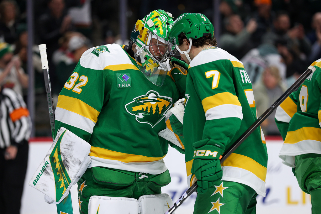 Minnesota Wild goaltender Filip Gustavsson, left, and defenseman Brock Faber (7) celebrate their win against the Dallas Stars after an NHL hockey game Thursday, Dec. 11, 2025, in St. Paul, Minn. (AP Photo/Matt Krohn)