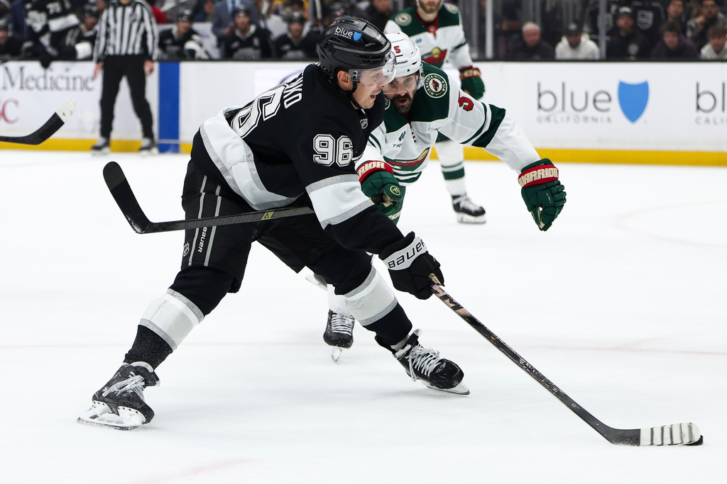 Los Angeles Kings left wing Andrei Kuzmenko (96) passes the puck as Minnesota Wild defenseman Jake Middleton, right, defends during the second period of an NHL hockey game, Monday, Jan. 5, 2026, in Los Angeles. (AP Photo/Jessie Alcheh)