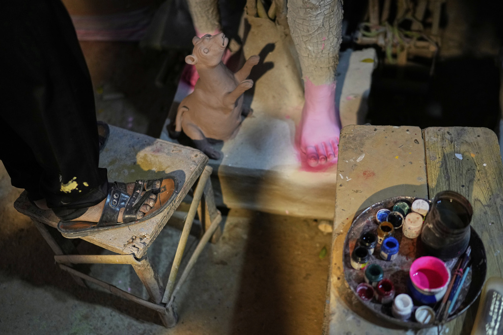 An artist from Kolkata paints an idol of the Hindu goddess Durga ahead of the Durga Puja festival in New Delhi, India, Friday, Sept. 19, 2025. (AP Photo/Manish Swarup)
