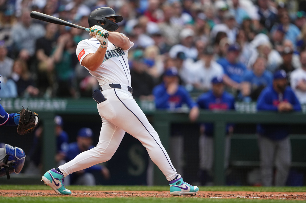 Seattle Mariners' Dominic Canzone hits a two-run single against the Texas Rangers during the fourth inning of a baseball game, Saturday, April 18, 2026, in Seattle. (AP Photo/Lindsey Wasson)