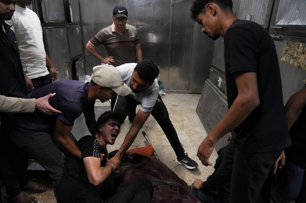 Palestinians mourn over the body of Mohammed Al-Harazin at the morgue of Shifa Hospital after he was killed in an Israeli airstrike on a vehicle in Gaza City, Sunday, June 7, 2026. (AP Photo/Jehad Alshrafi)