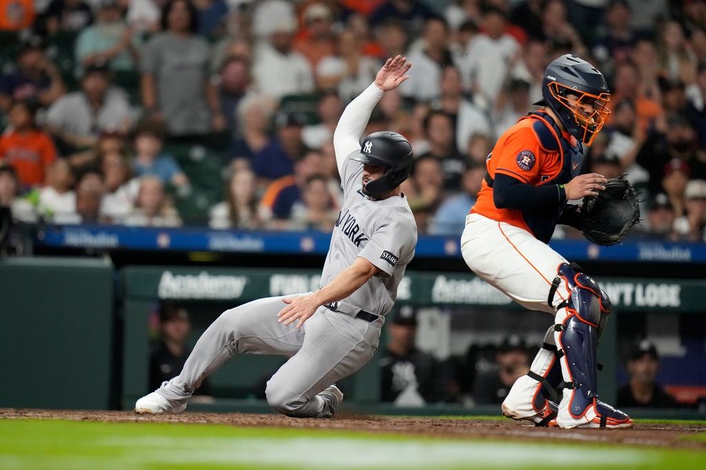 New York Yankees' Randal Grichuk scores a run on Jazz Chisholm Jr.'s RBI single during the seventh inning of a baseball game against the Houston Astros, Friday, April 24, 2026, in Houston. (AP Photo/ Karen Warren)