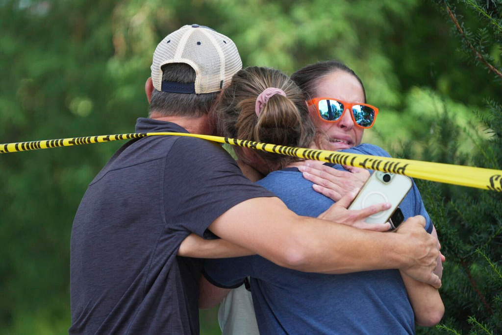 Community members embrace after a shooting at the Annunciation Catholic School on Wednesday, Aug. 27, 2025, in Minneapolis. (Alex Kormann/Star Tribune via AP)