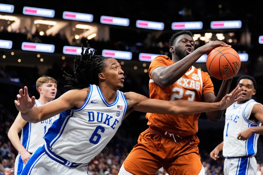 Duke forward Maliq Brown vies for the ball with Texas guard Chendall Weaver during the first half of an NCAA college basketball game, Tuesday, Nov. 4, 2025, in Charlotte, N.C. (AP Photo/Chris Carlson)