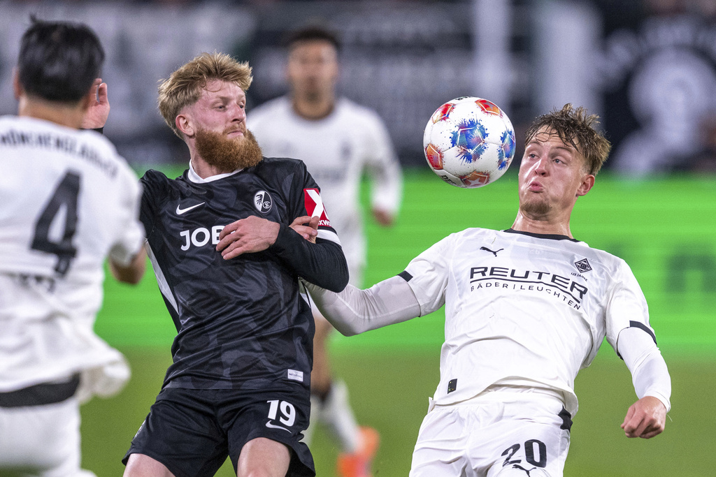 Mönchengladbach's Luca Netz, right, and Freiburg's Jan-Niklas Beste in action during the Bundesliga soccer match between Borussia Mönchengladbach and SC Freiburg at Stadion im Borussia-Park in Mönchengladbach, Germany, Sunday Oct. 5, 2025. (David Inderlied/dpa via AP)