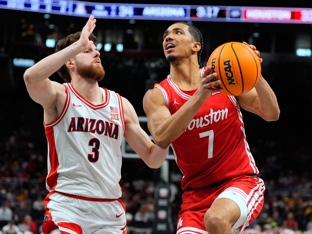 Houston's Milos Uzan (7) heads to the basket past Arizona's Anthony Dell'Orso (3) during the first half of an NCAA college basketball game in the championship of the Big 12 Conference tournament Saturday, March 14, 2026, in Kansas City, Mo. (AP Photo/Charlie Riedel)