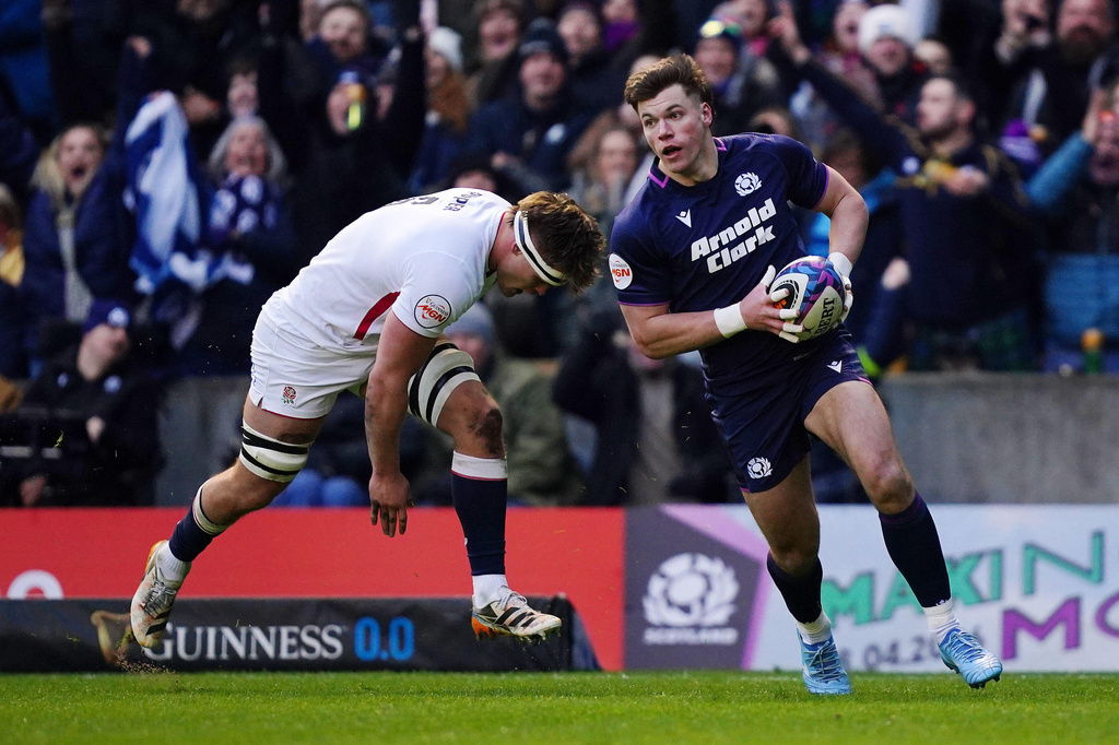 Scotland's Huw Jones, right, scores during the Six Nations rugby union match between Scotland and England in Edinburgh, Scotland, Saturday Feb. 14, 2026. (Jane Barlow/PA via AP)