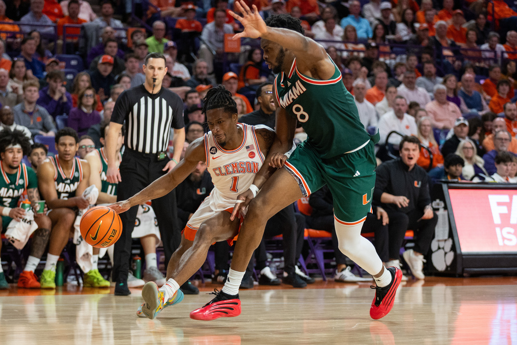 Clemson guard Jestin Porter (1) drives to the basket against Miami center Ernest Udeh Jr. (8) during the first half of an NCAA college basketball game Saturday, Jan. 17, 2026, in Clemson, S.C. (AP Photo/Scott Kinser)