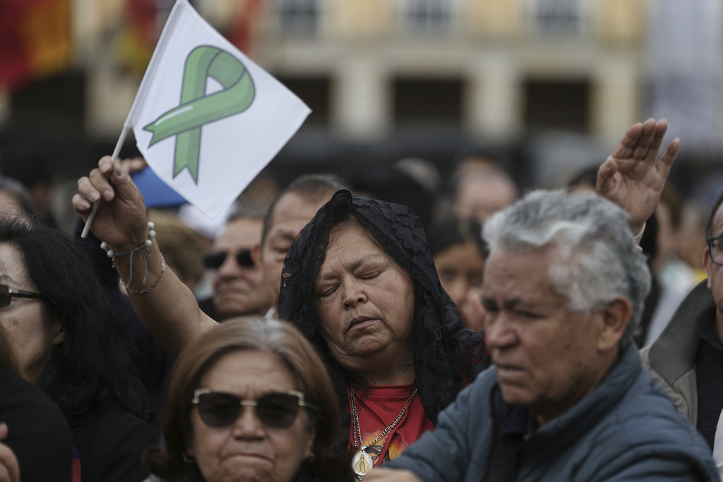 Mourners gather outside the cathedral in Bogota, Colombia, Wednesday, Aug. 13, 2025, during the funeral service for presidential hopeful and opposition Sen. Miguel Uribe, who died from wounds suffered when he was shot at a political rally. (AP Photo/Ivan Valencia)