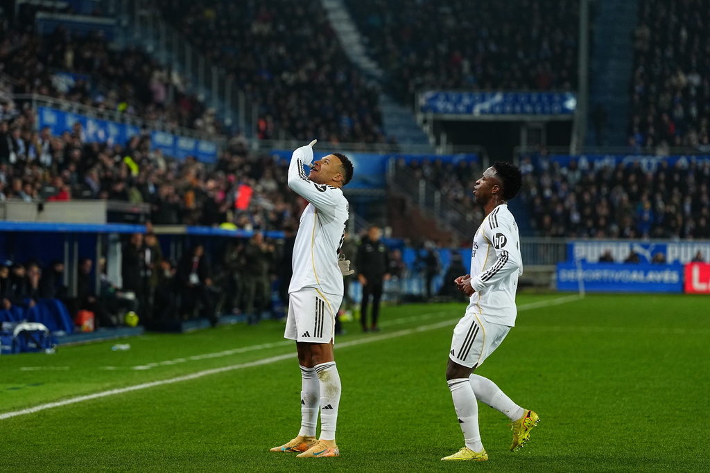 Real Madrid's Kylian Mbappe, left, celebrates with Real Madrid's Vinicius Junior after scoring the opening goal during the Spanish La Liga soccer match between Alaves and Real Madrid in Vitoria-Gasteiz, Spain, Sunday, Dec. 14, 2025. (AP Photo/Miguel Oses)