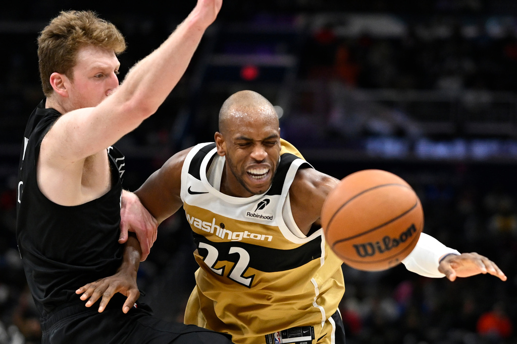 Washington Wizards forward Khris Middleton (22) is fouled by Brooklyn Nets forward Danny Wolf, left, during the first half of an NBA basketball game, Friday, Jan. 2, 2026, in Washington. (AP Photo/John McDonnell)