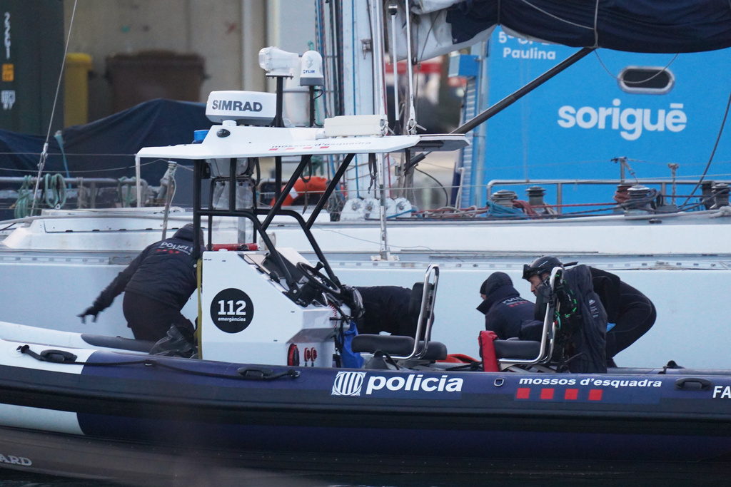 Police officers recover the body of a person found in the waters off the Port of Barcelona, Spain, Thursday, March 19, 2026. (AP Photo/Alfonso Beato)