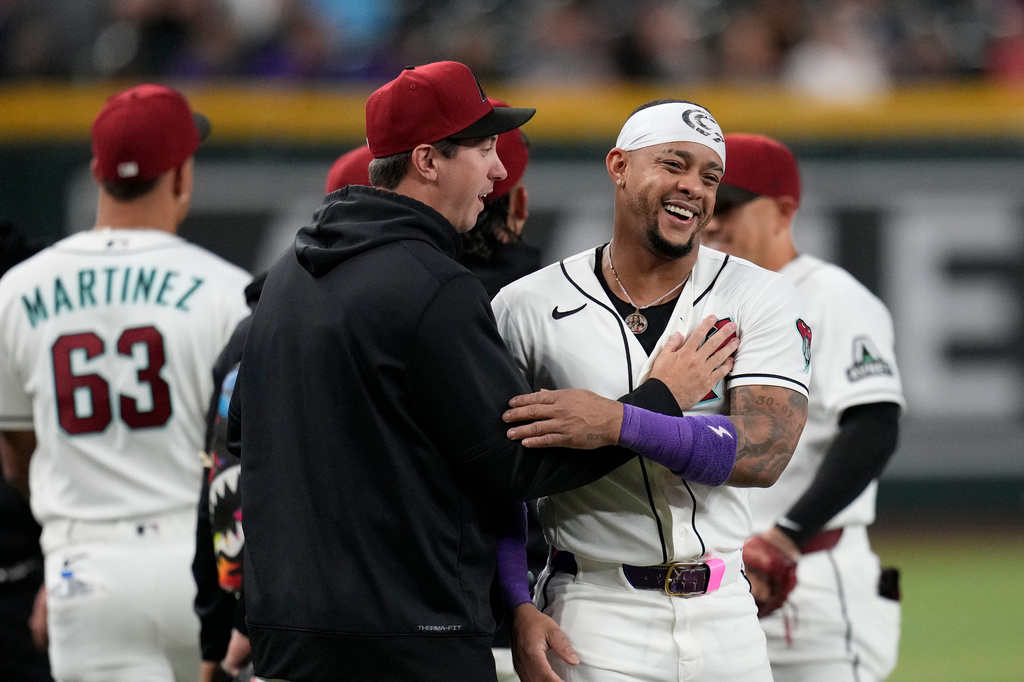 Arizona Diamondbacks' Ketel Marte, right, smiles as he is greeted by Diamondbacks' Derek Law prior to a baseball game against the Philadelphia Phillies, Monday, Aug. 31, 2026, in Phoenix. (AP Photo/Ross D. Franklin)