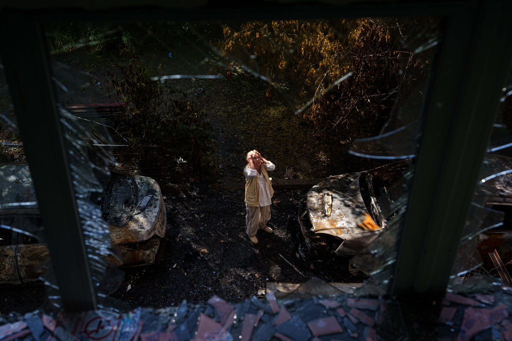 A woman reacts looking at a residential house damaged after a Russian strike on Kyiv, Ukraine, on Monday, June 15, 2026. (AP Photo/Evgeniy Maloletka)