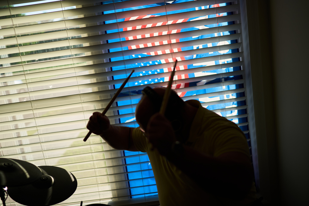 Brian Glick, who is fighting to recover the $575,000 stolen from him by a scammer online, plays the drums, Wednesday, June 25, 2025, at his home in Ballston Lake, N.Y. (AP Photo/David Goldman)