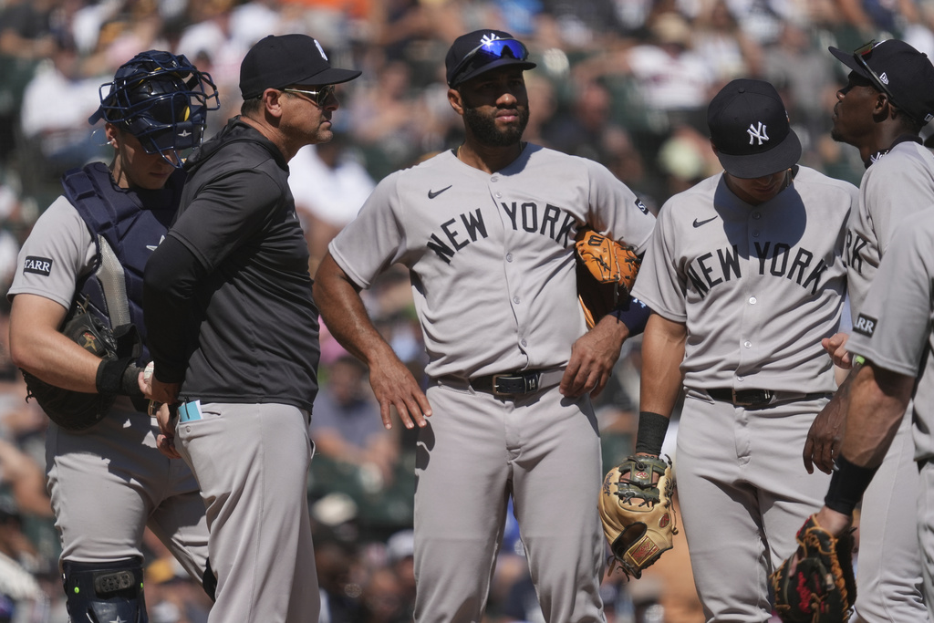 New York Yankees manager Aaron Boone, second from left, talks to players during the sixth inning of a baseball game against the Chicago White Sox in Chicago, Sunday, Aug. 31, 2025. (AP Photo/Nam Y. Huh)