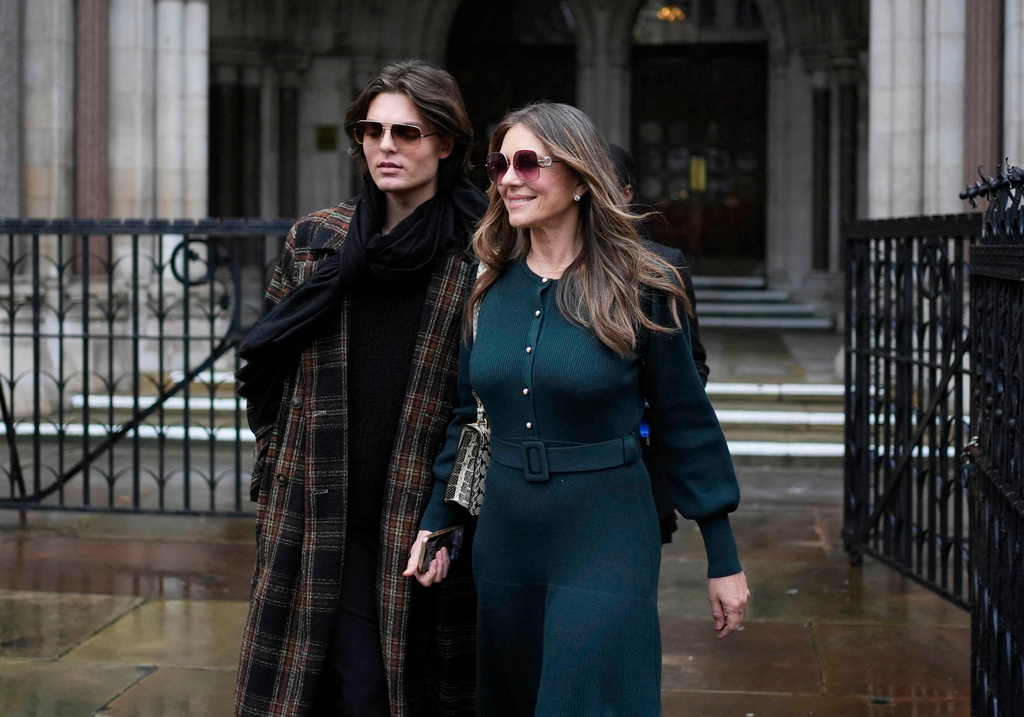 Elizabeth Hurley, right, leaves the Royal Courts of Justice on day four of the trial over allegations of unlawful information gathering brought against Associated Newspapers Limited, Thursday, Jan. 22, 2026, in London. (Jordan Pettitt/PA via AP)
