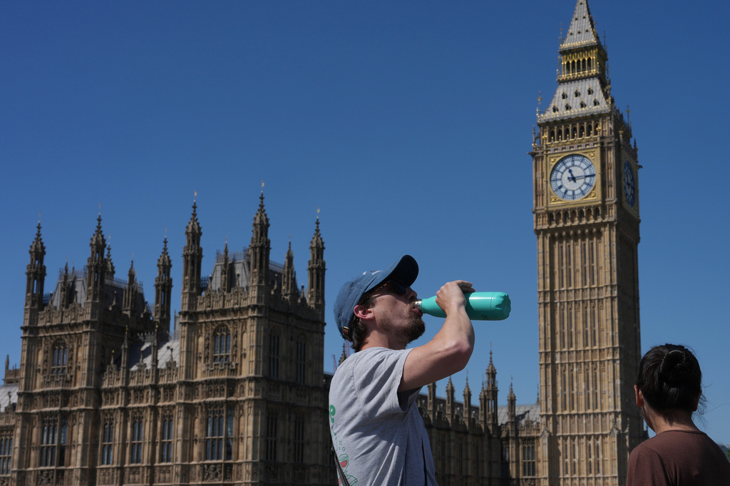 A man drinks outside the Palace of Westminster in London, Tuesday, May 26, 2026. (AP Photo/Kin Cheung)