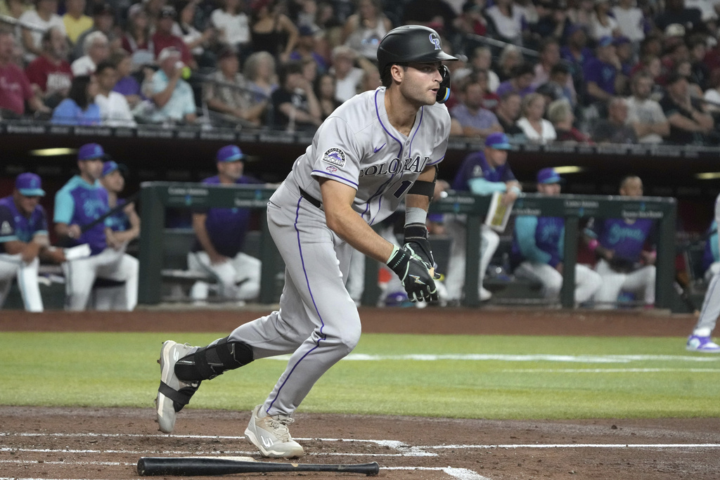 Colorado Rockies' Kyle Karros starts to run after hitting an RBI single on his major league at-bat debut against the Arizona Diamondbacks in the second inning of a baseball game, Friday, Aug. 8, 2025, in Phoenix. (AP Photo/Rick Scuteri)