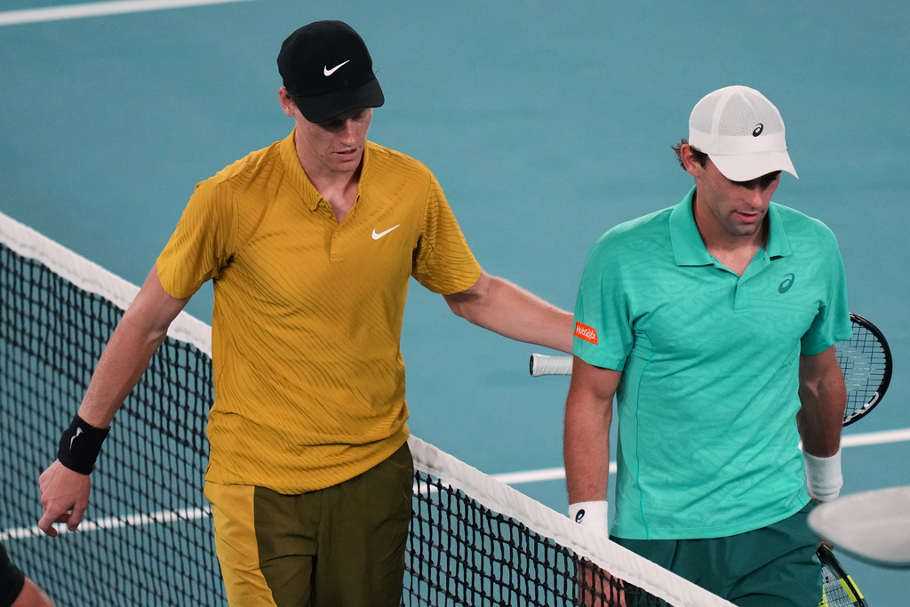 Jannik Sinner, left, of Italy walks from the court with Eliot Spizzirri of the U.S. after winning their third round match at the Australian Open tennis championship in Melbourne, Australia, Saturday, Jan. 24, 2026. (AP Photo/Dar Yasin)