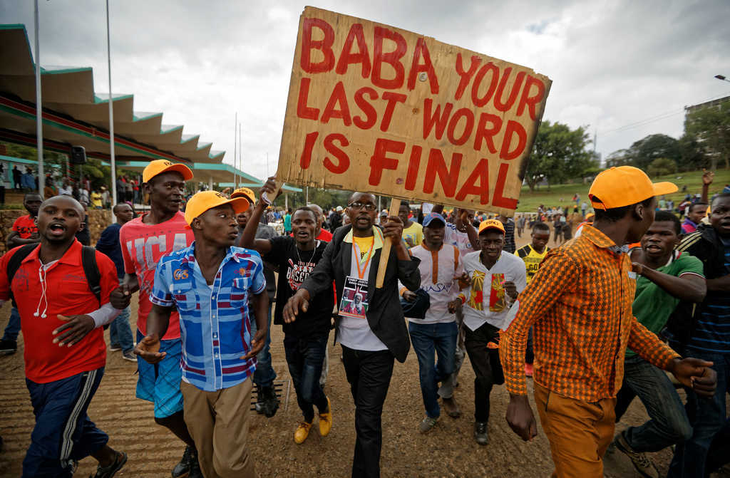 Supporters of opposition leader Raila Odinga march with a placard referring to him as "Baba", the Swahili word of respect meaning "Father", as they start to hold a rally in Uhuru Park in downtown Nairobi, Kenya Wednesday, Oct. 25, 2017. (AP Photo/Ben Curtis)