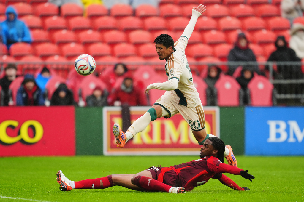 Atlanta United's Cayman Togashi (30) shoots at goal as Toronto FC's Zane Monlouis (12) defends during the first half of an MLS soccer game in Toronto, Saturday, April 25, 2026. (Frank Gunn/The Canadian Press via AP)