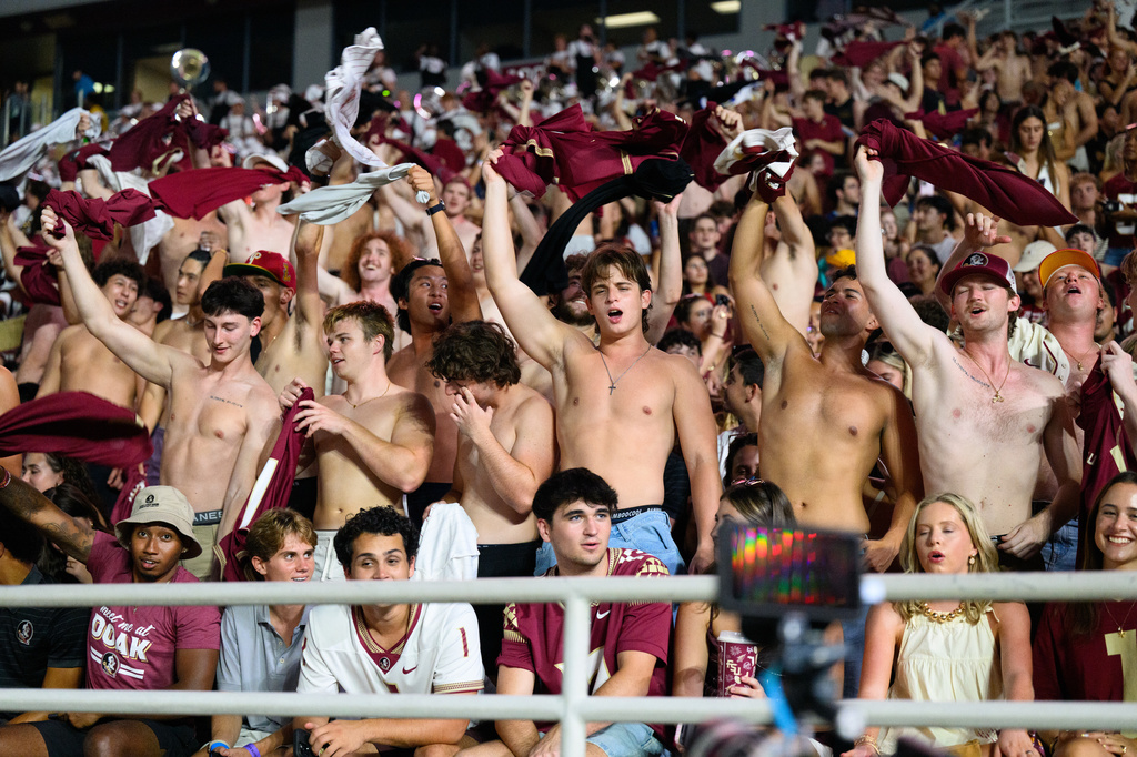 Florida State students wave their shirts during a stadium-wide power outage before an NCAA college football game against SMU, Monday, Sept. 7, 2026, in Tallahassee, Fla. (AP Photo/Noah Lantor)