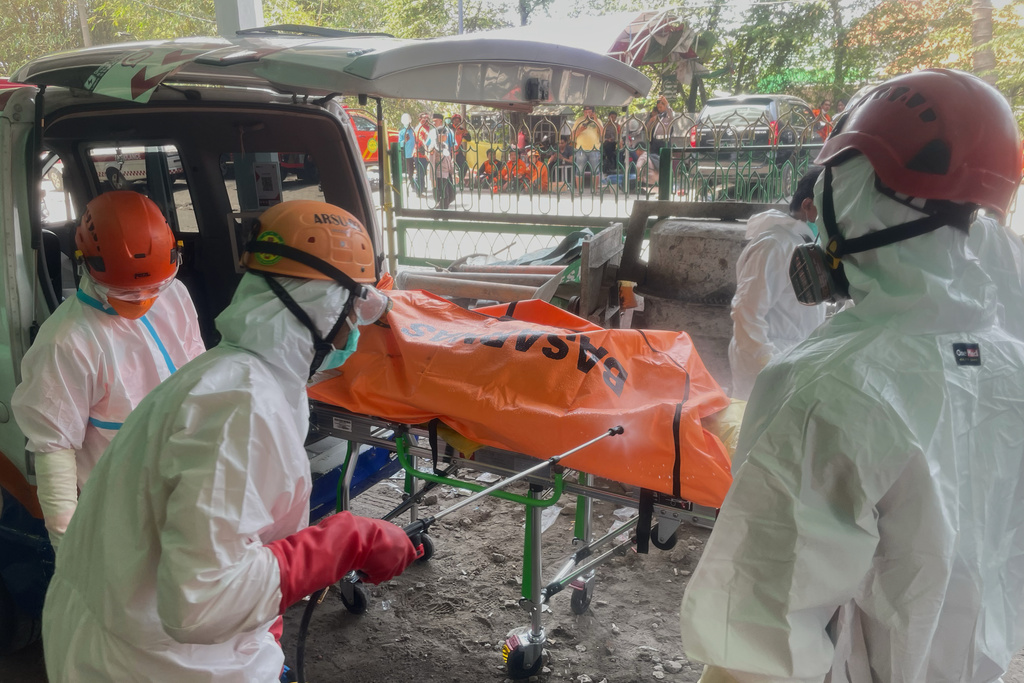 Rescuers disinfect the body bag containing the body of a victim of a collapsed building at an Islamic boarding school in Sidoarjo, East Java, Indonesia, Friday, Oct. 3, 2025. (AP Photo/Trisnadi)