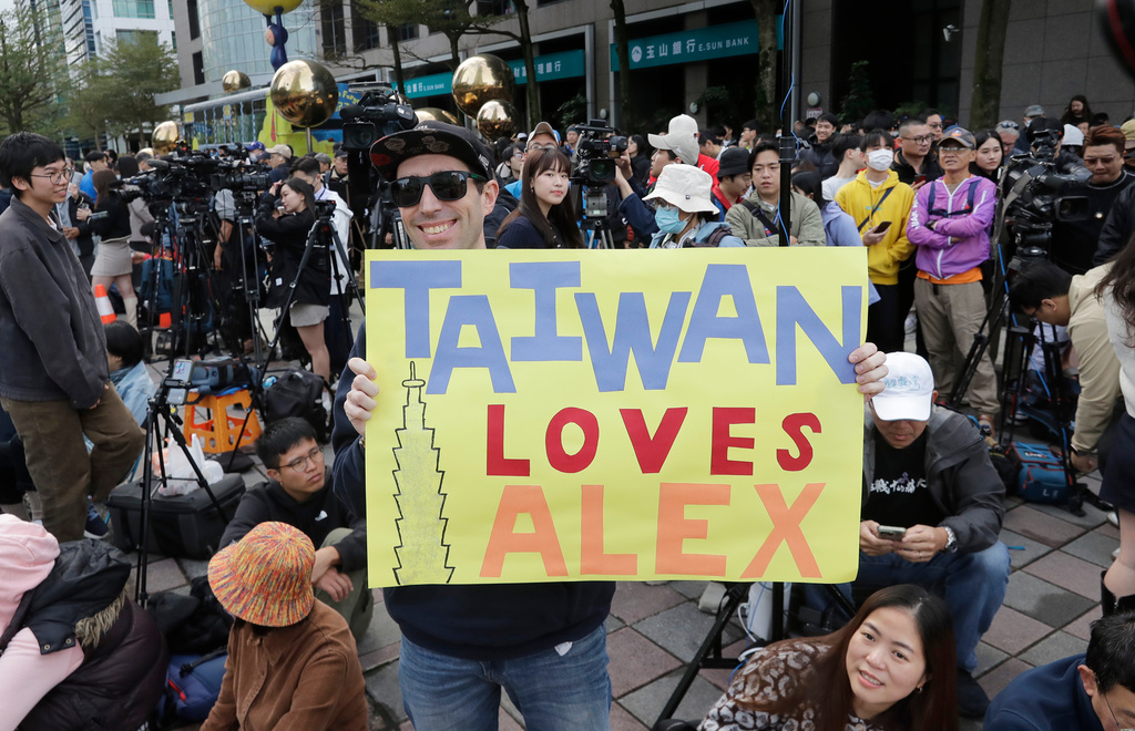 A fan of rock climber Alex Honnold, of the U.S., shows a poster before Honnold climbs the Taipei 101 skyscraper in Taipei, Taiwan, Sunday, Jan. 25. 2026. (AP Photo/Chiang Ying-ying)