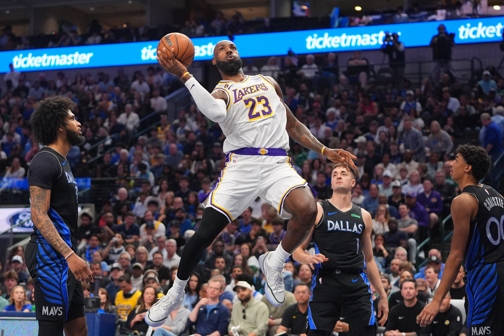 Los Angeles Lakers forward LeBron James (23) drives to the basket against Dallas Mavericks defenders John Poulakidas (1), Max Christie (00) and Naji Marshall during the first half of an NBA basketball game in Dallas, Sunday, April 5, 2026. (AP Photo/LM Otero)