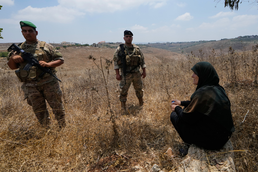 Lebanese army soldiers stand near a woman after preventing her from entering the southern village of Zawtar Al Gharbieh, Lebanon, Wednesday, July 22, 2026. (AP Photo/Mohammed Zaatari)