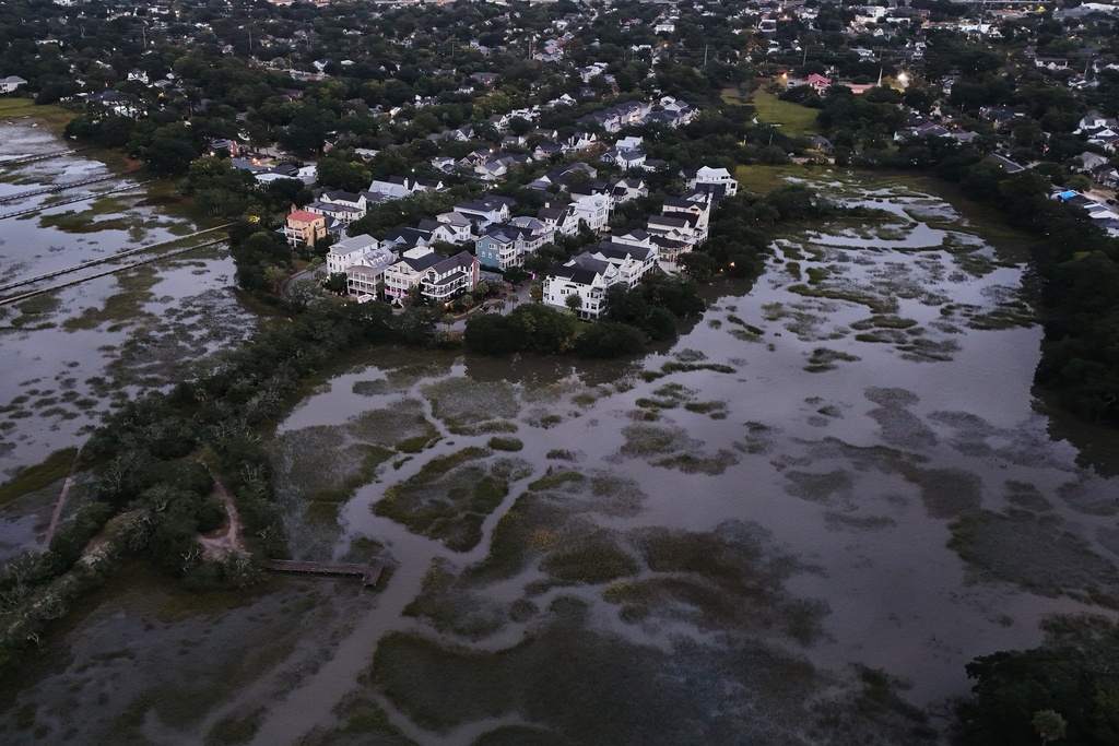 Houses sit next to a salt marsh at high tide, Monday, Oct. 6, 2025, in Charleston, S.C. (AP Photo/Joshua A. Bickel)