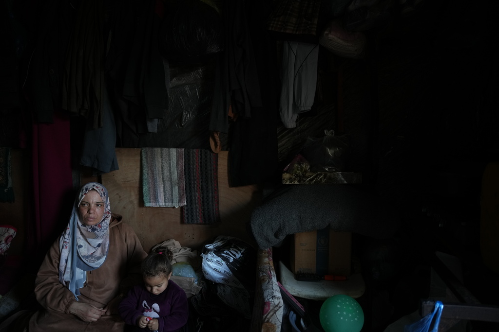 Rana al-Louh, 45, sits with her granddaughter, Sumaya Abu Suleiman, 3, inside the tent where they live, which had been erected in a schoolyard converted into a shelter in Nuseirat, in the central Gaza Strip, Saturday, Feb. 7, 2026. (AP Photo/Abdel Kareem Hana)