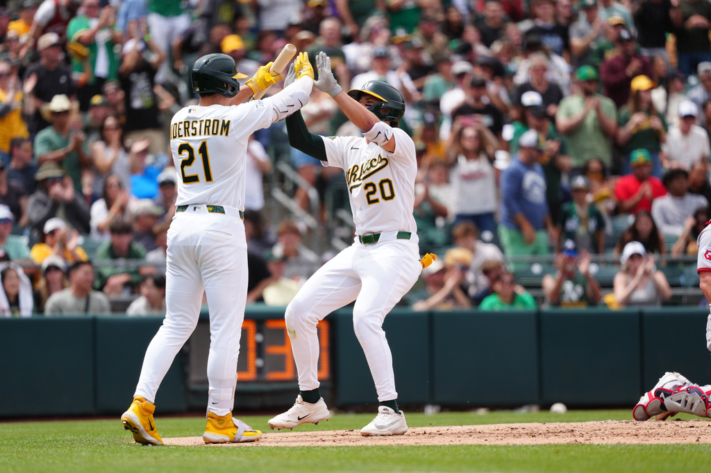 Athletics' Zack Gelof (20) is greeted at home plate by teammate Tyler Soderstrom (21) in the fifth inning of a baseball game against the Cleveland Guardians, Sunday, May 3, 2026, in West Sacramento, Calif. (AP Photo/Alan Greth)