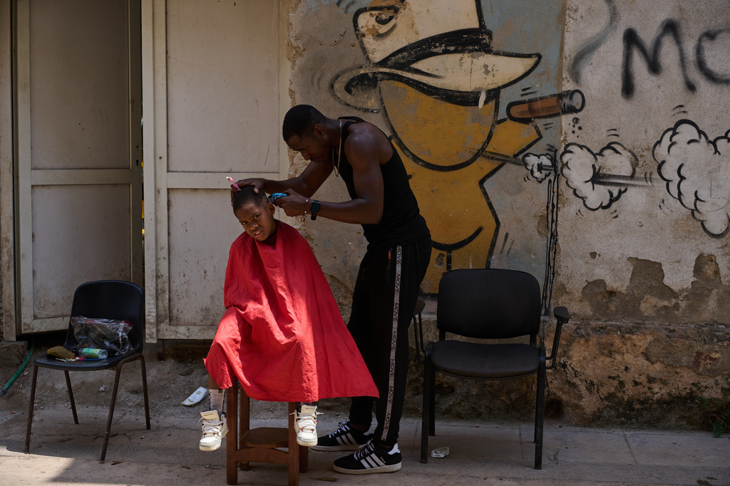A barber cuts a boy's hair at his makeshift barbershop on the street in Havana, Wednesday, April 22, 2026. (AP Photo/Ramon Espinosa)