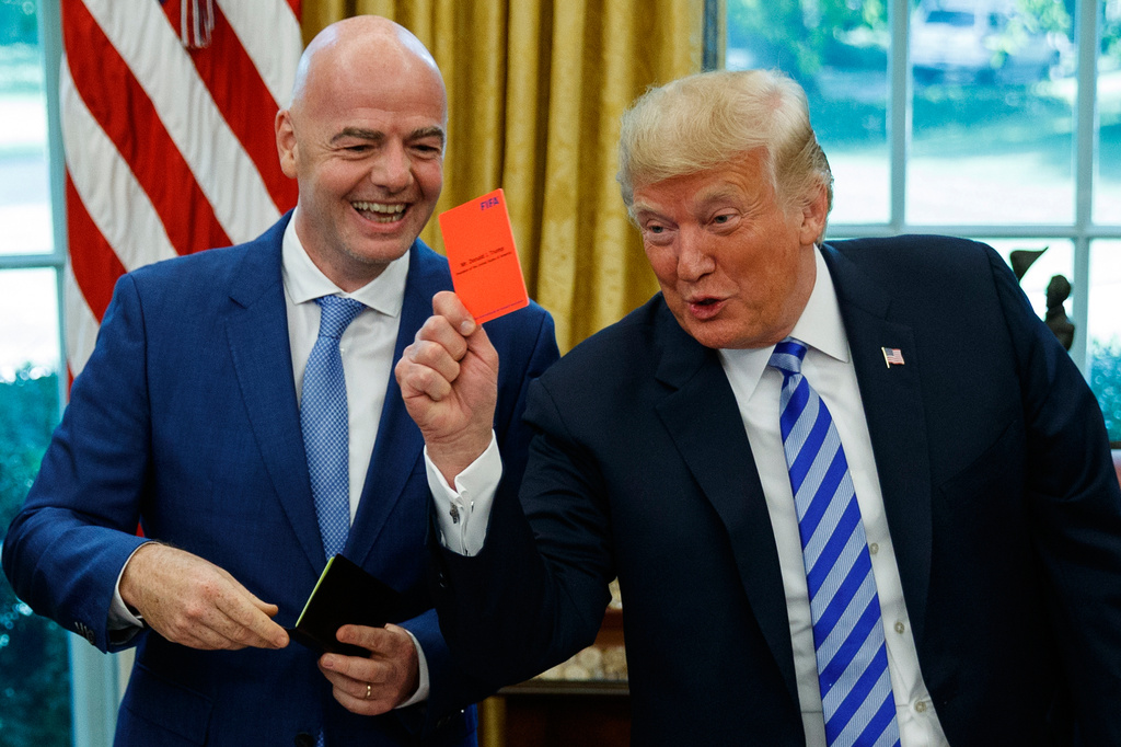 FILE - President Donald Trump holds up a red card during a meeting with FIFA president Gianni Infantino in the Oval Office of the White House, Tuesday, Aug. 28, 2018, in Washington. (AP Photo/Evan Vucci, File)