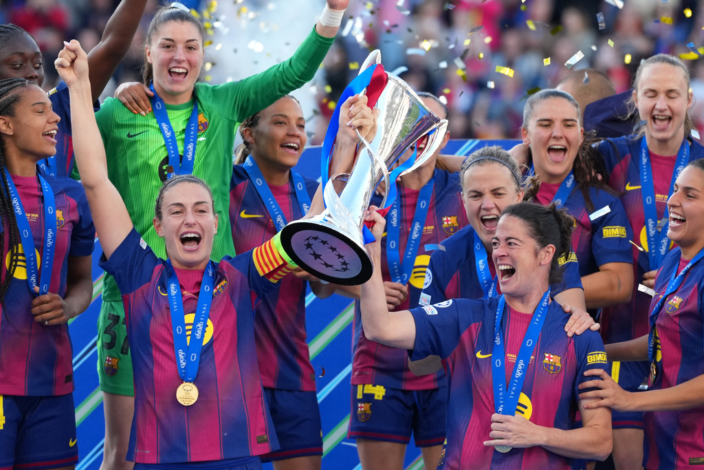 Barcelona's Alexia Putellas, left, and Marta Torrejon celebrate with the trophy after winning the Women's Champions League final soccer match between FC Barcelona and OL Lyonnes, in Oslo, Saturday, May 23, 2026. (AP Photo/Kirsty Wigglesworth)