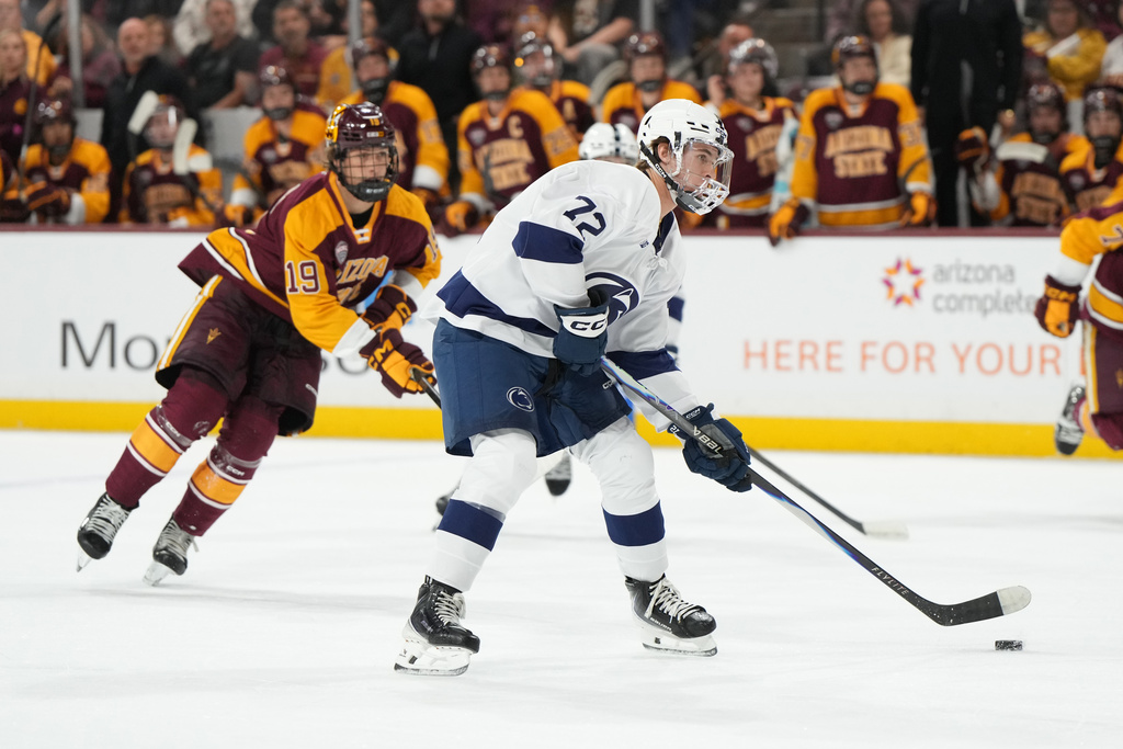 Penn State's Gavin McKenna, center, looks to shoot against Arizona State during the first period of an NCAA college hockey game, Friday, Oct. 3, 2025, in Tempe, Ariz. (AP Photo/Rick Scuteri)