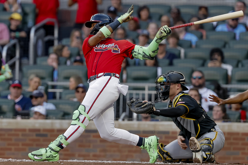 Atlanta Braves' Ronald Acuna Jr., left, hits an RBI single as Pittsburgh Pirates catcher Henry Davis, right looks on during the second inning of a baseball game, Friday, June 5, 2026, in Atlanta. (AP Photo/Erik S. Lesser)