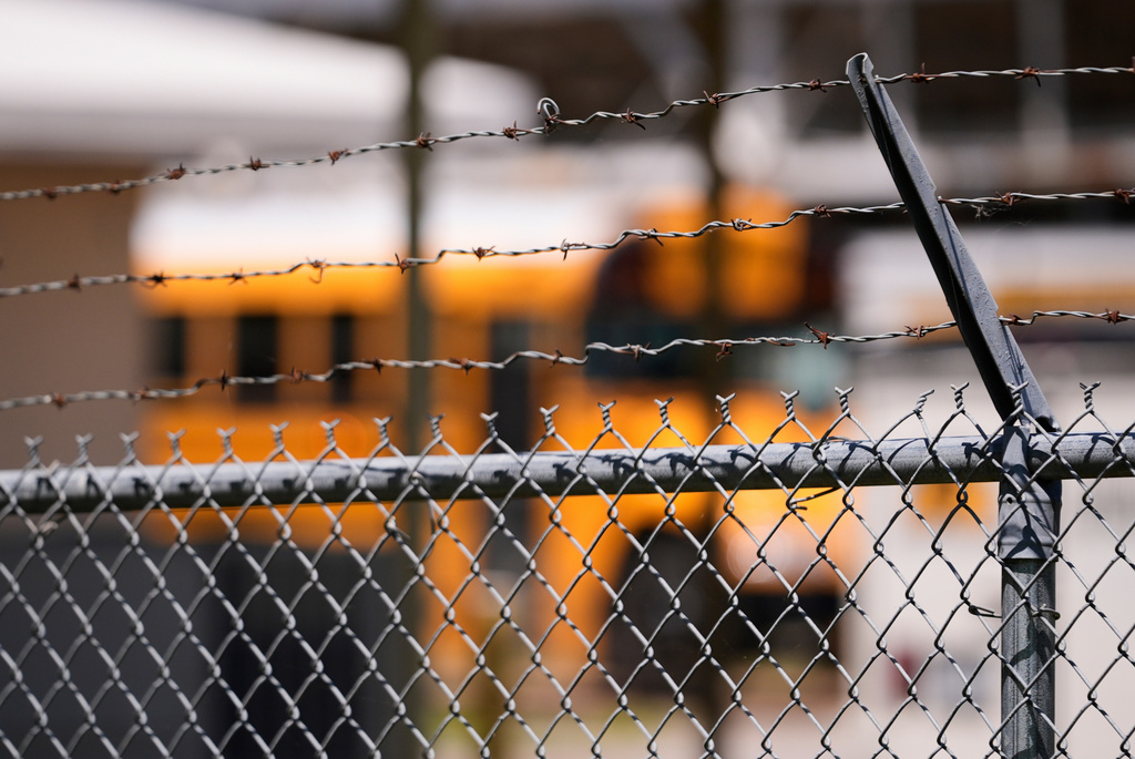 FILE - A school bus is seen behind a fence with barbed wire outside Ferriday High School in Ferriday, La., May 22, 2025. (AP Photo/Gerald Herbert, File)