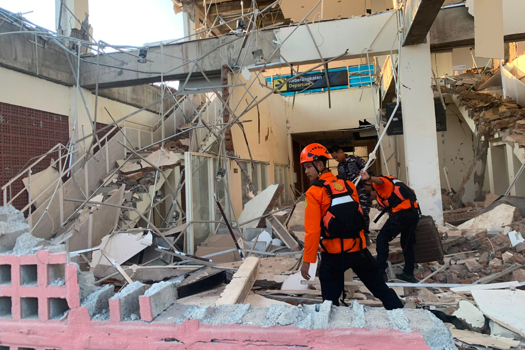 In this photo released by the Indonesian National Search and Rescue Agency (BASARNAS), rescuers search for victims at a damaged building following an earthquake in Maumere, East Nusa Tenggara Province, Indonesia, Saturday, Aug. 15, 2026. (BASARNAS via AP)