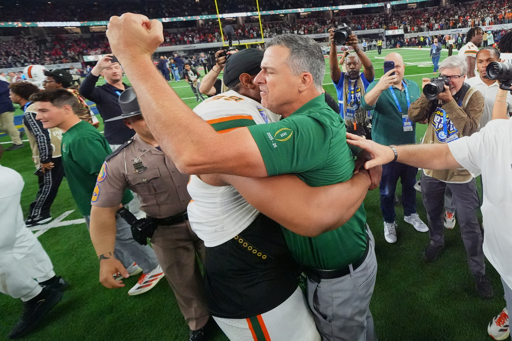 Miami head coach Mario Cristobal, right, hugs defensive lineman Ahmad Moten Sr. following the Cotton Bowl College Football Playoff quarterfinal game against Ohio State Wednesday, Dec. 31, 2025, in Arlington, Texas. (AP Photo/Julio Cortez)