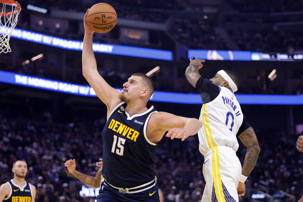 Denver Nuggets' Nikola Jokic (15) out rebounds Golden State Warriors' Gary Payton II (0) during the first half of an NBA basketball game in San Francisco on Thursday, Oct. 23, 2025. (Scott Strazzante/San Francisco Chronicle via AP)