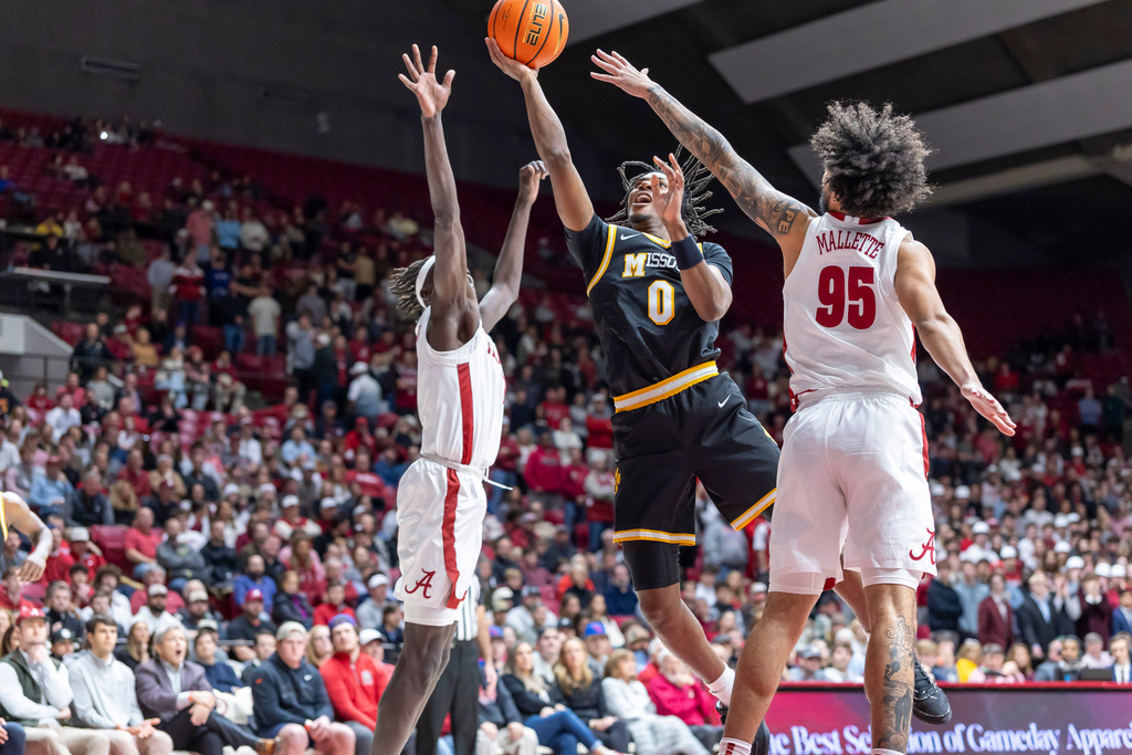 Missouri guard Anthony Robinson II (0) shoots between Alabama forward Taylor Bol Bowen, left, and guard Houston Mallette (95) during the first half of an NCAA college basketball game Tuesday, Jan. 27, 2026, in Tuscaloosa, Ala. (AP Photo/Vasha Hunt)