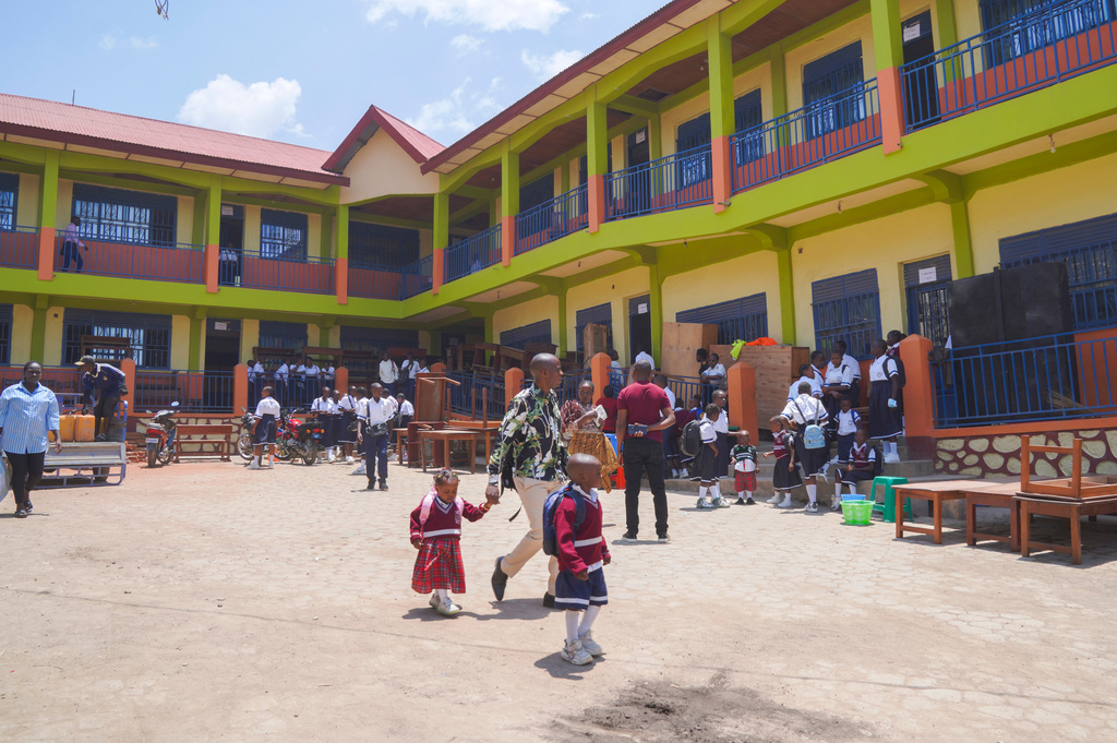 A parent walks his daughter in a schoolyard on the first day of the new school year, amid the Ebola virus outbreak, in Ituri, Congo, Tuesday, Sept.1, 2026. (AP Photo/Dieudonne Dirole)